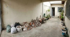 Mini entulho ocupando espaço em área residencial, indicando a necessidade de serviço particular de descarte